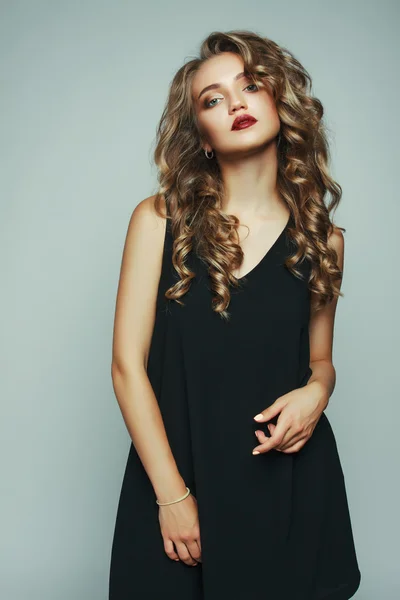Zarif siyah elbiseli genç bayanın moda fotoğrafı.