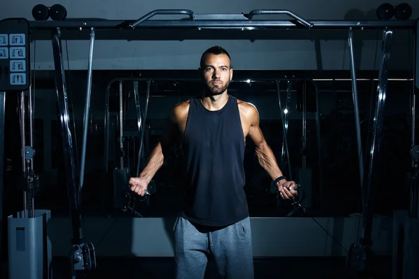 Bodybuilder guy in gym pumping up hands close up — Stock Photo, Image