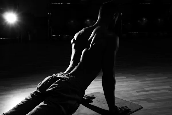 Vacker muskulös man flexar tillbaka muskler på bänk i gymmet. Blac — Stockfoto