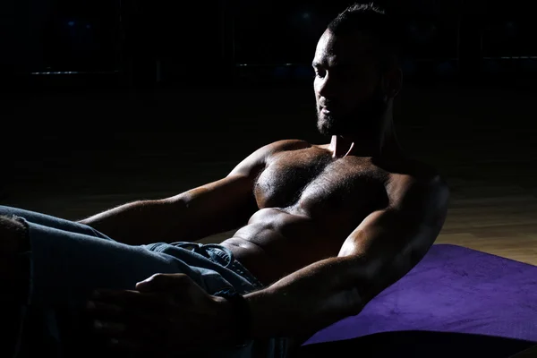 Kaslı adam egzersizleri yapmak için spor salonu Studio karın