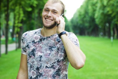 Yakışıklı adam cep telefonu çağrı gülümseme açık şehir sokak, genç