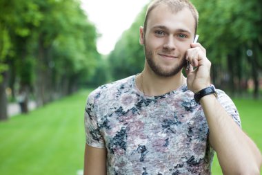 bir bahçe telefonda konuşurken yakışıklı bir adam. Yeşil Garden.Ha