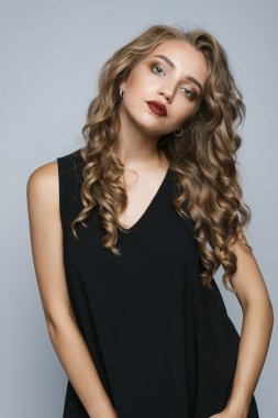 Stüdyoda siyah elbiseli güzel bir kız. Kız str ayakta