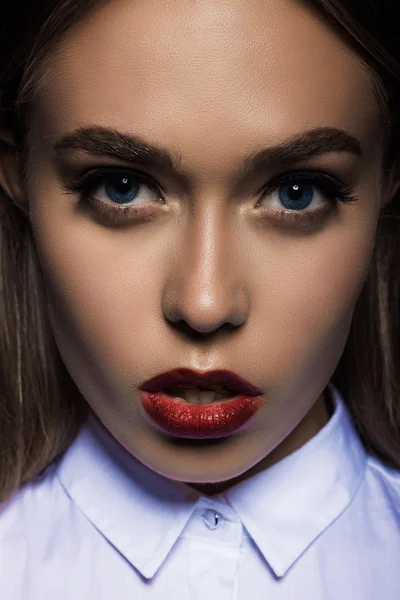 Giovane donna con labbra rosse su uno sfondo nero in studio — Foto Stock