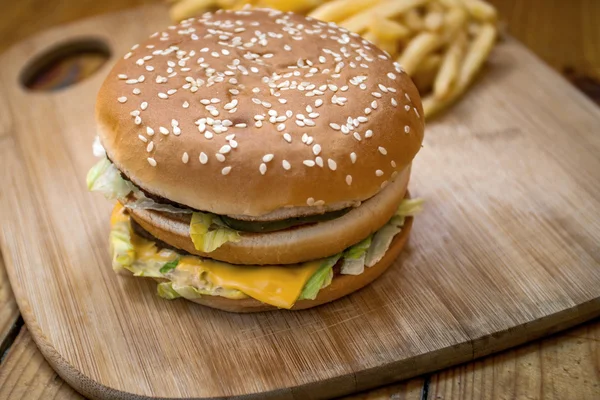 Fast food mis gros hamburger et frites sur fond de bois — Photo