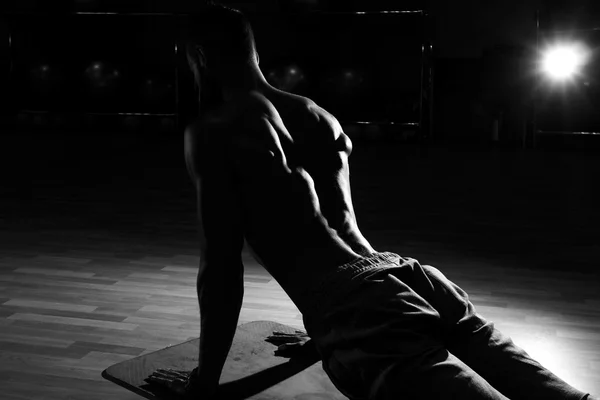 Spor salonunda bankta yakışıklı kaslı adam geri esneme kaslar. Blac