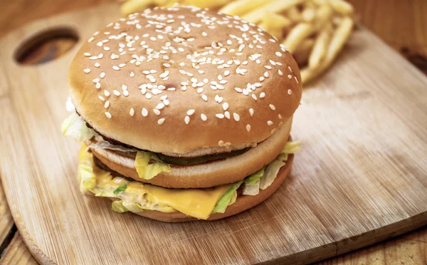 Snabbmat som stora hamburgare och pommes frites på trä bakgrund — Stockfoto