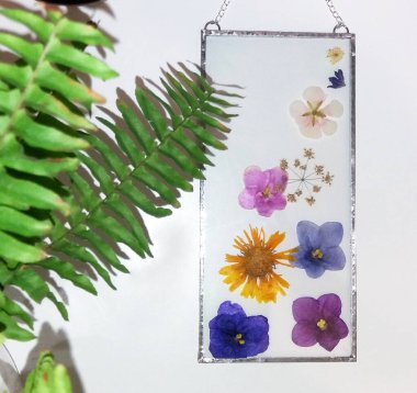 Renkli camdaki Tiffany tekniğinde çerçevelenmiş baskılı çiçekler.