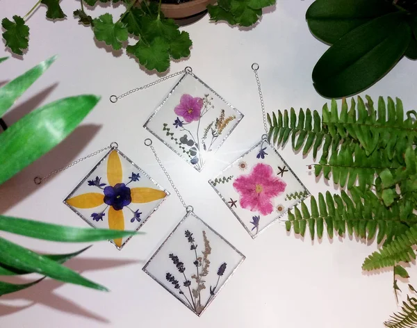 Renkli camdaki Tiffany tekniğinde çerçevelenmiş baskılı çiçekler.