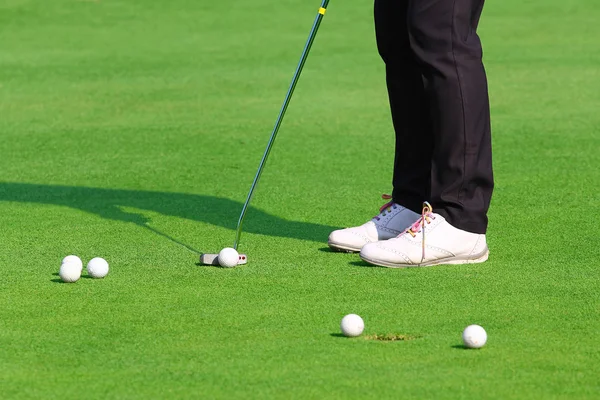 bir golf topu deliğe koyarak golfçü