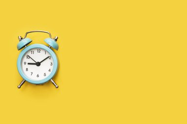 Sarı zemin üzerinde klasik alarm saati.