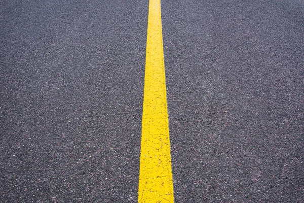 The dividing strip is yellow. Smooth asphalt surface with a yellow stripe. Road signs and symbols.