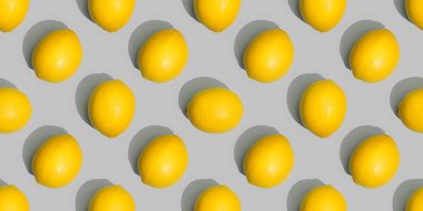 Gri bir arka planda limonların pürüzsüz deseni. Yılın Pantone rengi.