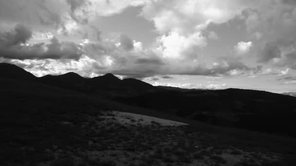 Pluizige wolken boven de bergen — Stockvideo