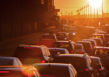 Arabalar güzel bir altın gün batımı sırasında trafik sıkışıklığı vardır.