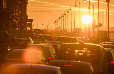 Arabalar güzel bir altın gün batımı sırasında trafik sıkışıklığı vardır.