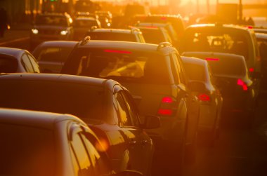 Arabalar güzel bir altın gün batımı sırasında trafik sıkışıklığı vardır.