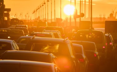Arabalar güzel bir altın gün batımı sırasında trafik sıkışıklığı vardır.