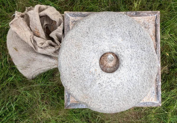 Древняя каменная ручная мельница с зерном — стоковое фото