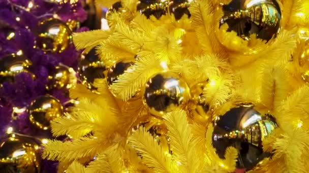 Magia hermosa Navidad y Año Nuevo fondo. Árboles de Navidad de colores artificiales con grandes bolas de oro y luces de Navidad centelleantes. Purple y amarillo abetos artificiales primer plano telón de fondo — Vídeos de Stock