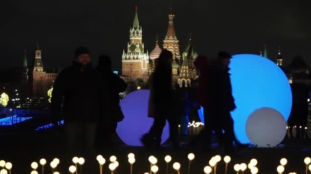 모스코 - 2019 년 12 월 29 일: 자르야다예 공원에서 사람들이 모스크바 크렘린의 배경과 축제 조명 장식에 반대하여 사진을 찍음 — 비디오