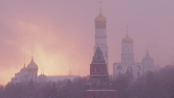 Ryssland, Moskva, Den stora klocktornet Ivan är ett kyrktorn inne i Moskva Kreml komplexet. Utsikt över Kreml en snöig vinterdag. Katedralen Vasily den välsignade i tung snöstorm väder — Stockvideo