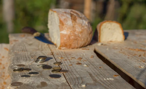 Pan sobre una mesa con monedas y cuchillo. Desenfocado —  Fotos de Stock