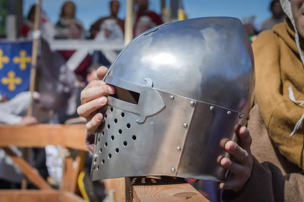 Человек на рыцарском турнире держит рыцарский шлем. — стоковое фото