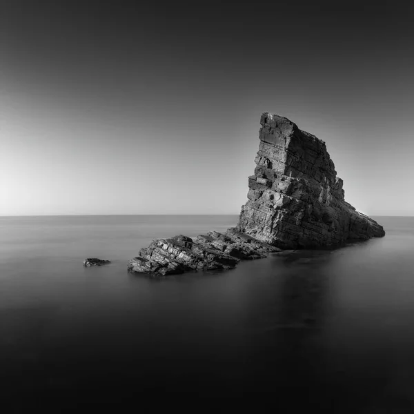 Low angle view of natural landmark The stone ships near Sinemorets, Bulgaria. Black and white landscape of rocks in calm sea water. Long exposure. Low shutter speed