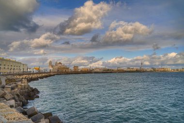 Atlantik 'e yansıyan altın rengi, sakin kumlar ve tarihi ufuk çizgisi ile Cadiz sahilinde büyüleyici bir gün batımı. Yüksek kalite fotoğraf