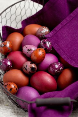 Mor ve kahverengi sepet Paskalya yumurtaları renkli.