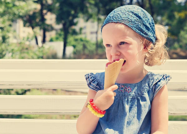 Funny little girl (3 years) eat ice cream.