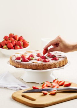 Ev yapımı Çilekli pasta bir beyaz pasta stand.