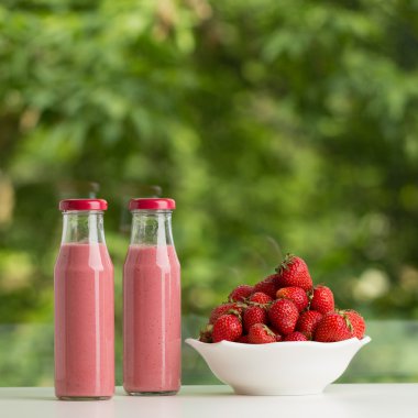 Cam şişe yeşil zemin üzerine çilek güler yüzlü.