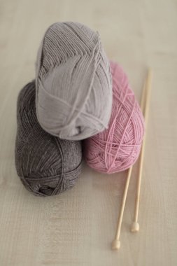 Ahşap örgü iğneleri ve örgü iplikleri. Pembe ve kahverengi. Seçici odak.