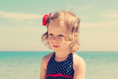 Küçük kız sahilde. Görüntü renkli.