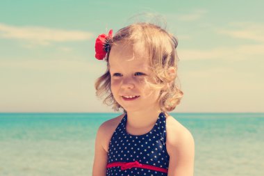 Küçük kız sahilde. Görüntü renkli.