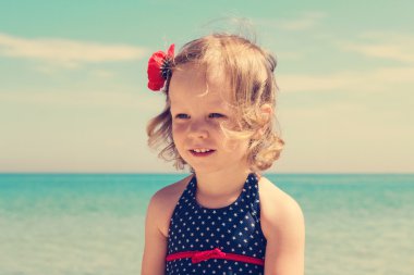 Küçük kız sahilde. Görüntü renkli.