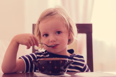 Küçük şirin kız çorba yiyor.