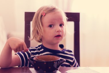 Küçük şirin kız çorba yiyor.