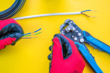 Elektrikçi kablolardan izolasyonu söküyor - ellere ve penseye yakın çekim