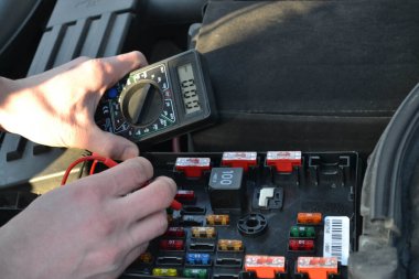 Tamirci araba tamirhanesinde araba tamir ediyor.