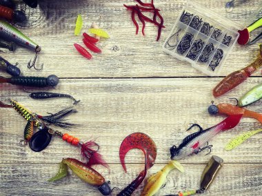 Tahta arka planda izole edilmiş olta, bobin ve balık yemi, üst manzara.