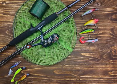 Balık oltası. Tahta bir arka planda süzülür, sallanır, oltaya yem takılır. Seçici odak