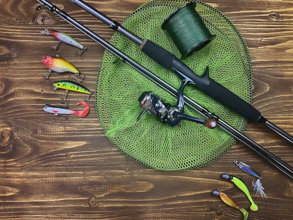 Fishing tackle. Float, wobbler, bait hooks, on a wooden background. Selective focus