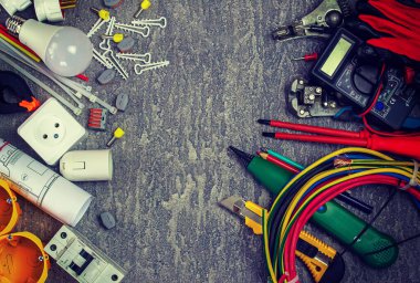 Elektriksel araçlar ve metin için bir yer ile gri bir arkaplan üzerinde elektrik tesislerinde kullanmak için bir takım bileşenler