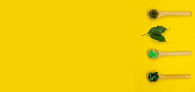 Tahta kaşıkta bitkisel tabletleri karıştırdım. Gıda takviyesi.