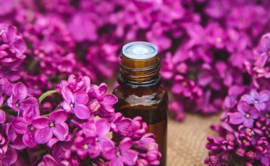 Küçük bir şişedeki leylak yağı. Seçici odaklanma. Doğa.