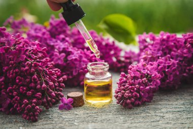 Küçük bir şişedeki leylak yağı. Seçici odaklanma. Doğa.