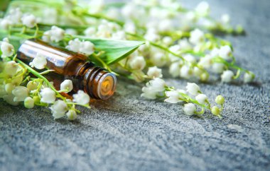 Vadideki zambak, küçük bir şişede gerekli yağ. Seçici odaklanma. Doğa.